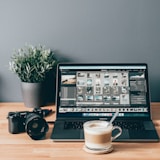 black laptop computer beside white ceramic mug on brown wooden table