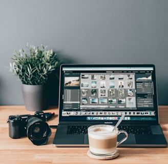 black laptop computer beside white ceramic mug on brown wooden table