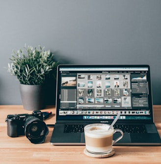 black laptop computer beside white ceramic mug on brown wooden table