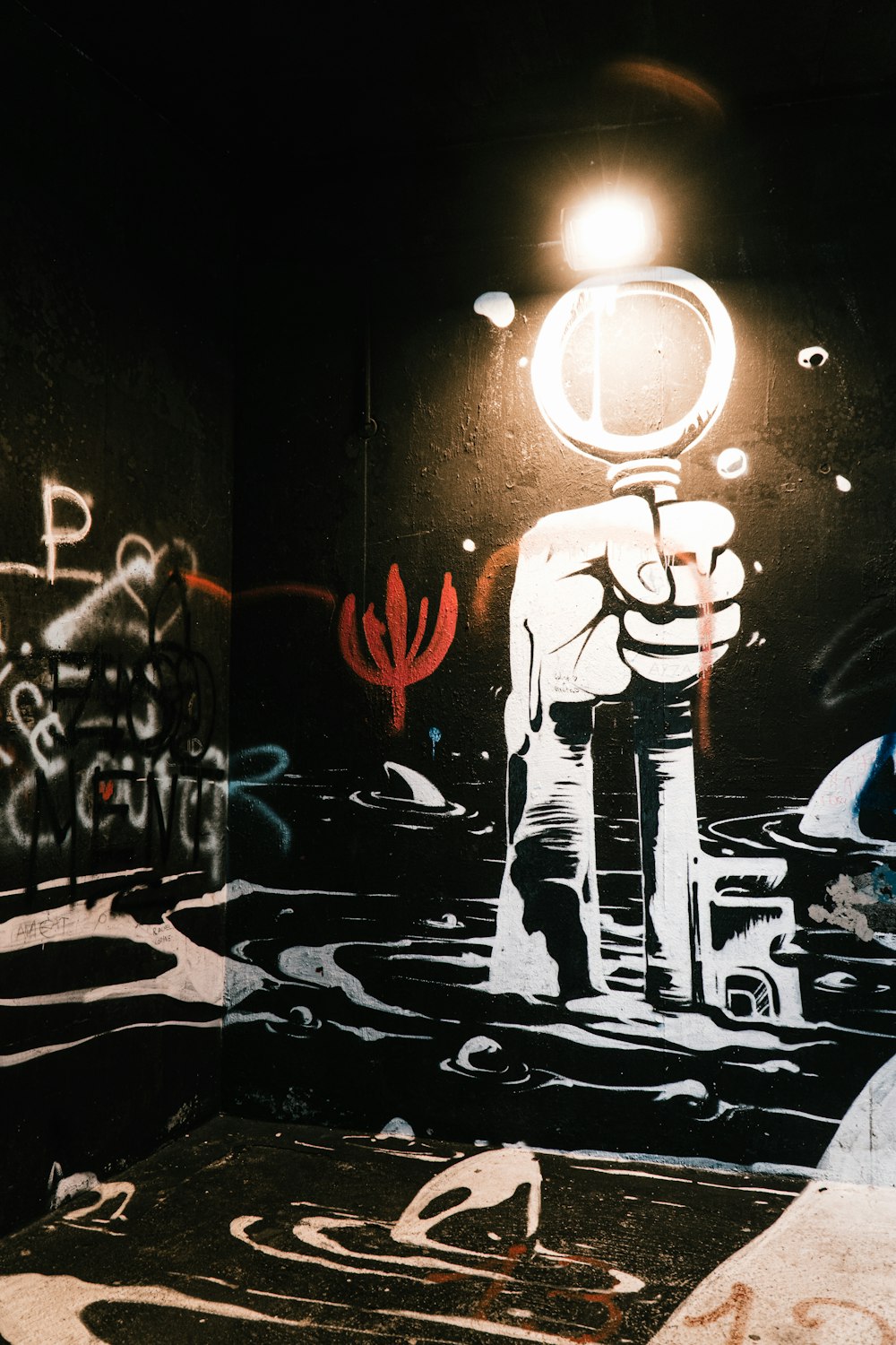 homem em jaqueta de terno preto e calças em pé na frente da parede com grafite