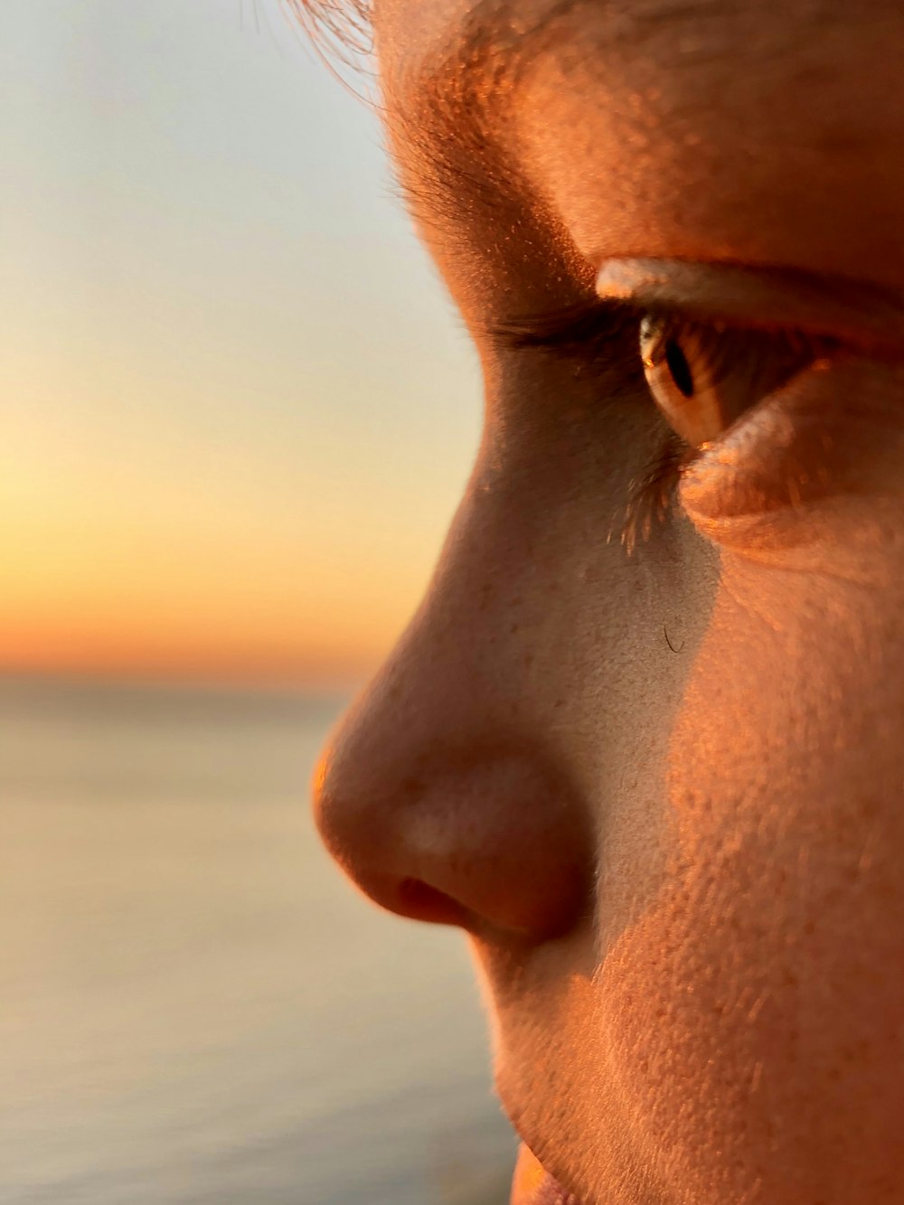 mans face in close up photography during sunset