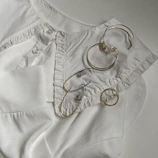 Flat lay of Korean fashion jewellery including earrings and necklaces on a neutral fabric.