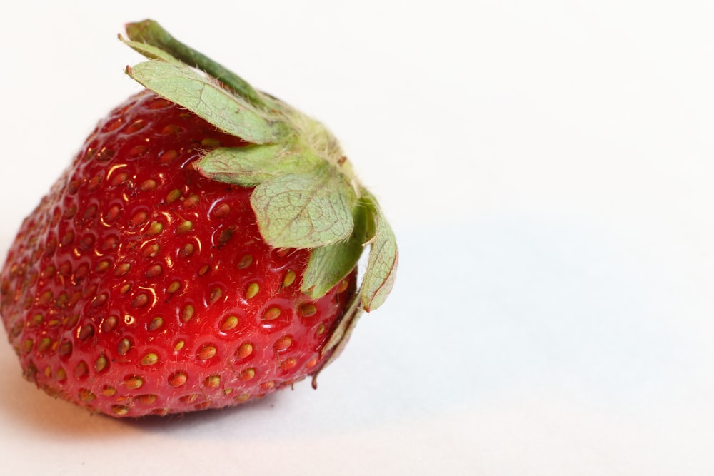 red strawberry on white surface