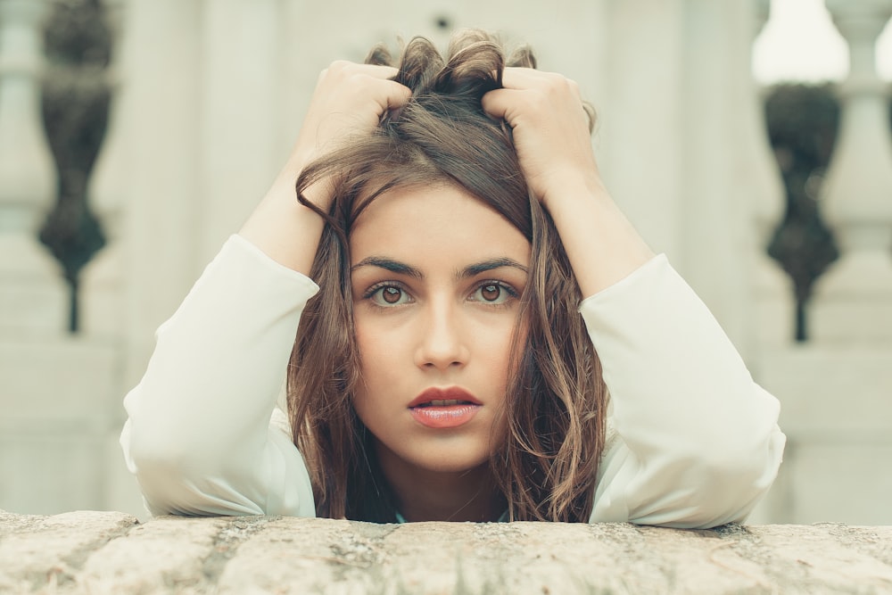 woman in white long sleeve shirt lying on bed