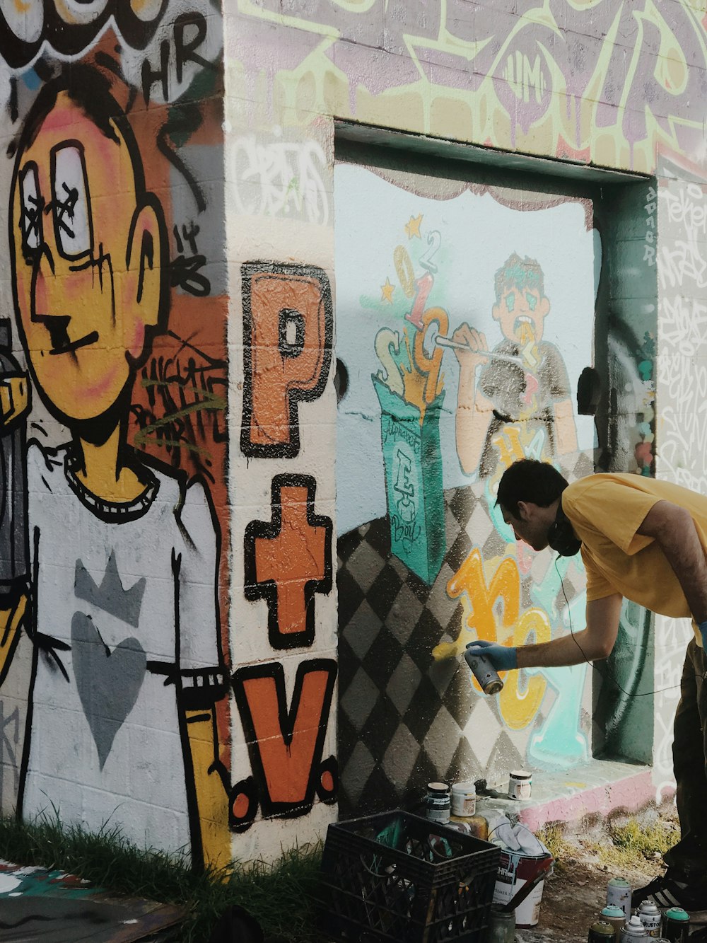 Mann im weißen T-Shirt steht in der Nähe der Wand mit Graffiti