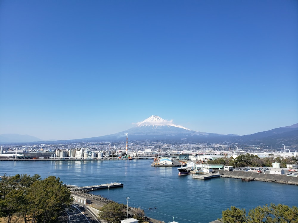 white and black buildings near body of water under blue sky during daytime