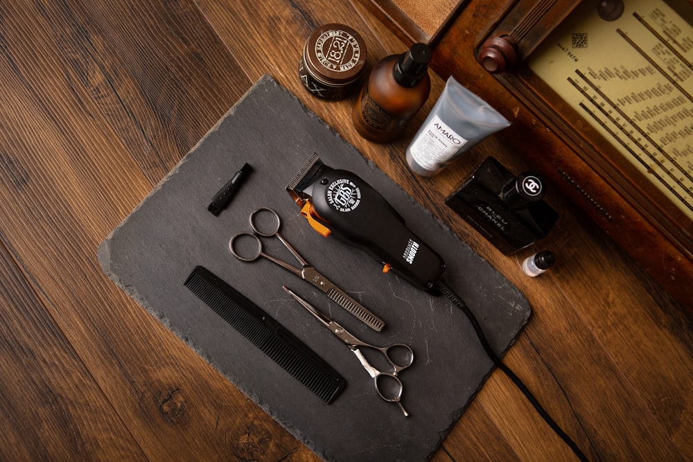 black and silver scissors and black framed eyeglasses on black textile