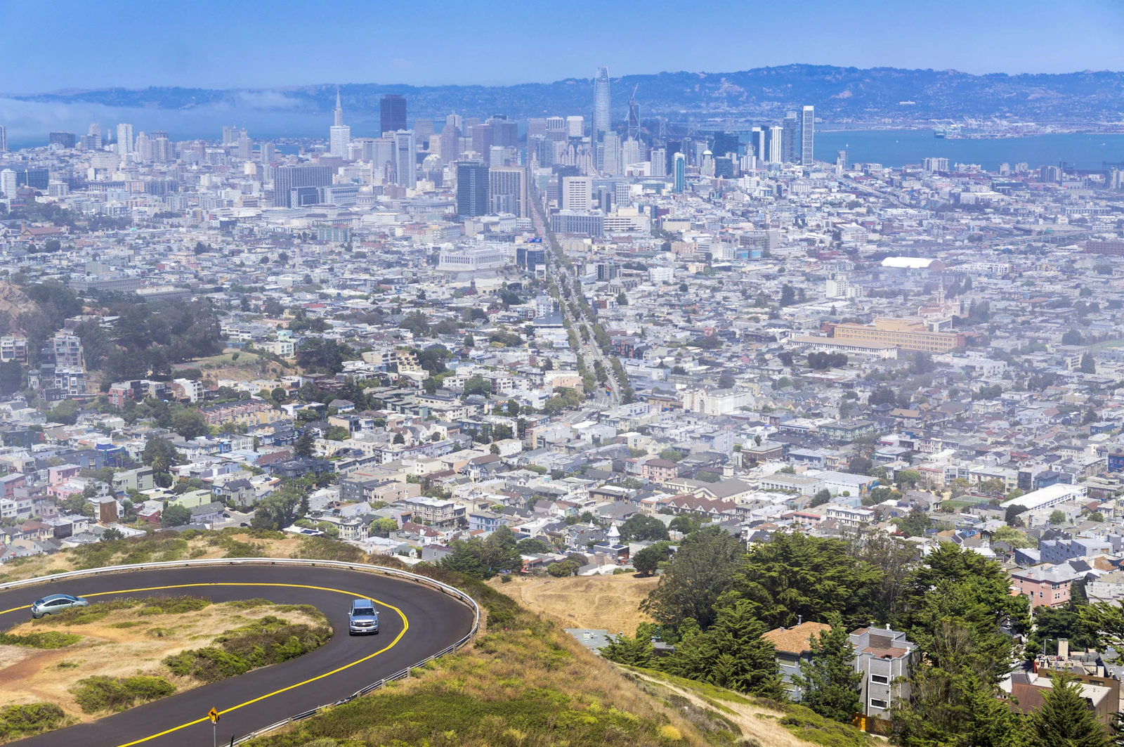 An aerial view of a dense valley city under haze.