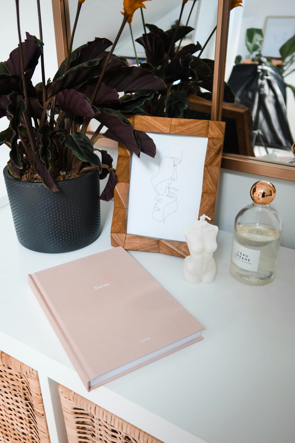 white ceramic angel figurine beside pink book