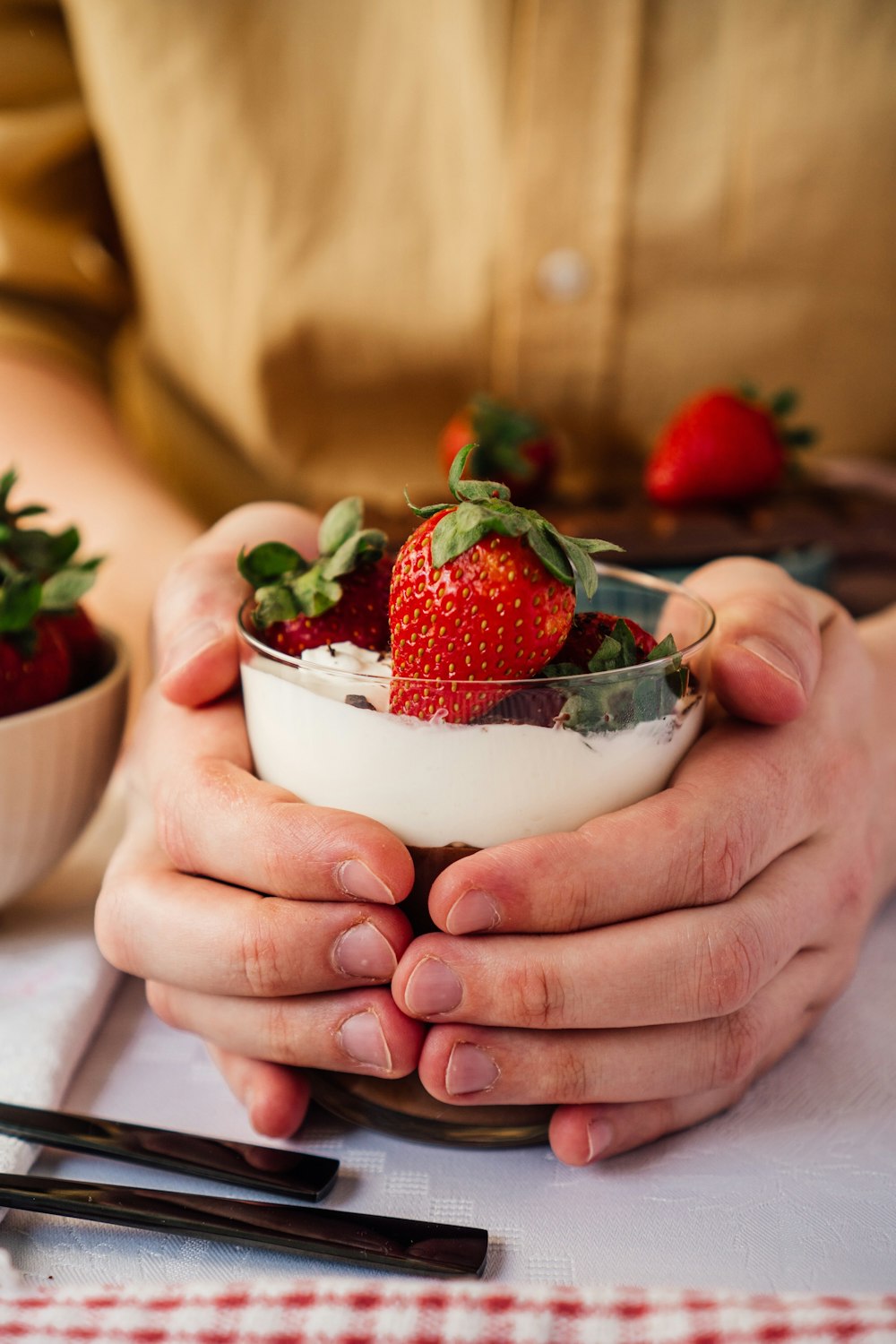 person holding bowl of strawberries