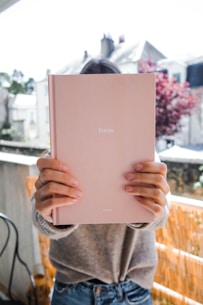 person holding white ipad during daytime