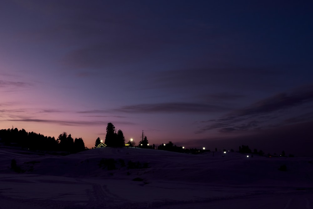 silhouette of people on snow covered field during night time