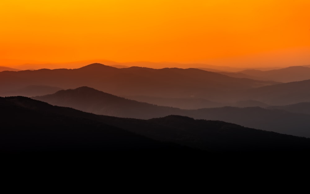 silhueta das montanhas durante o pôr do sol