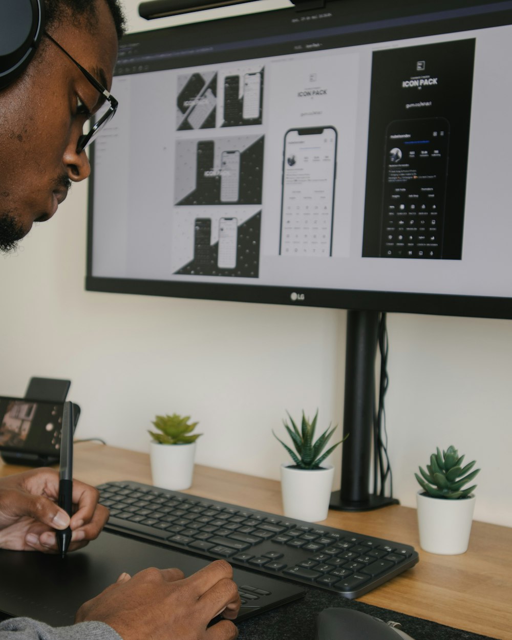 Mann in schwarz gerahmter Brille mit schwarzem Smartphone