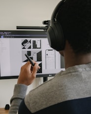 man in gray sweater holding black smartphone