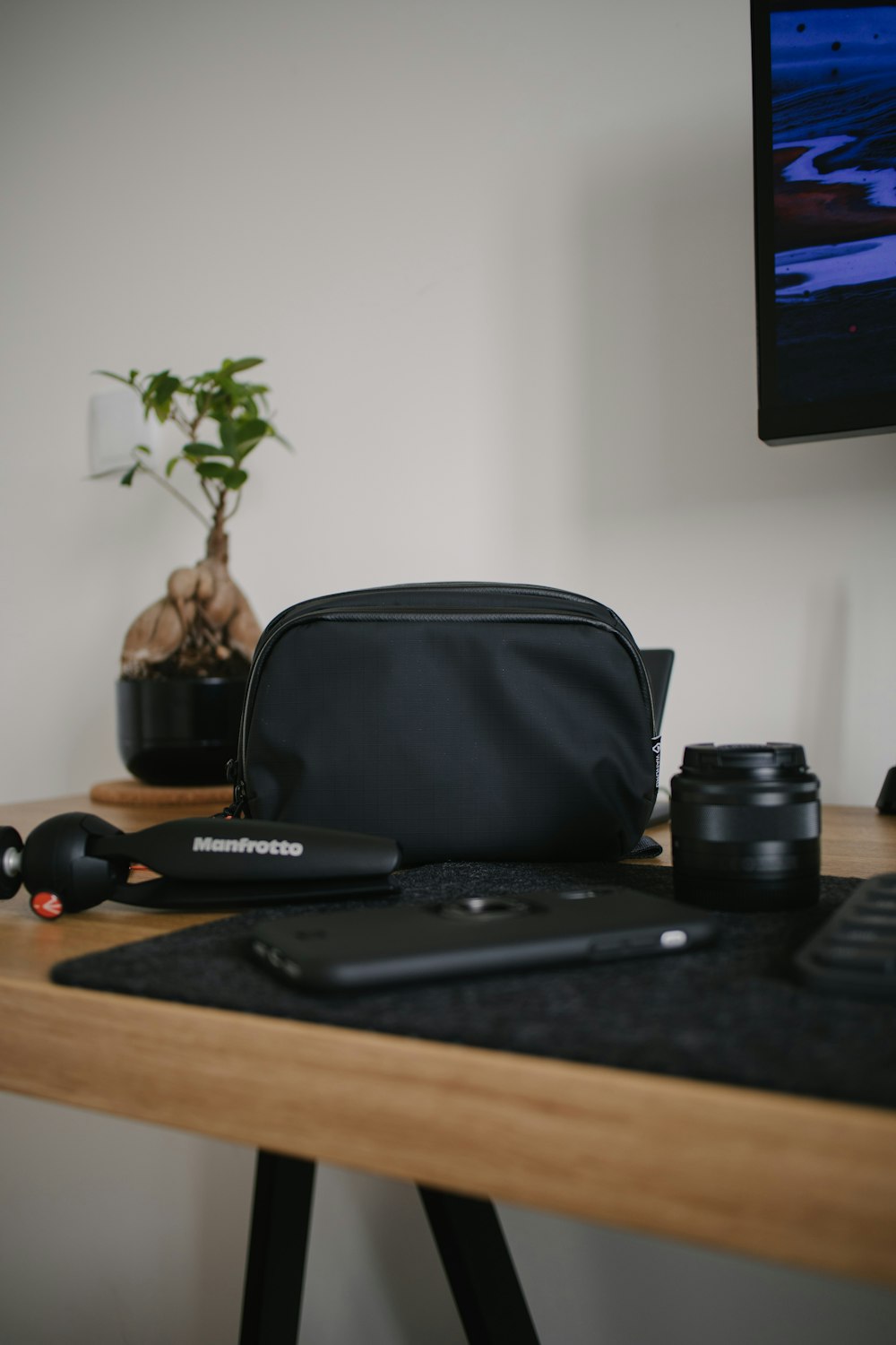 black laptop computer beside black leather bag on brown wooden table