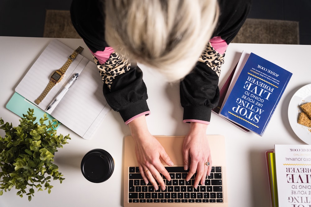 woman in black and pink long sleeve shirt using macbook pro