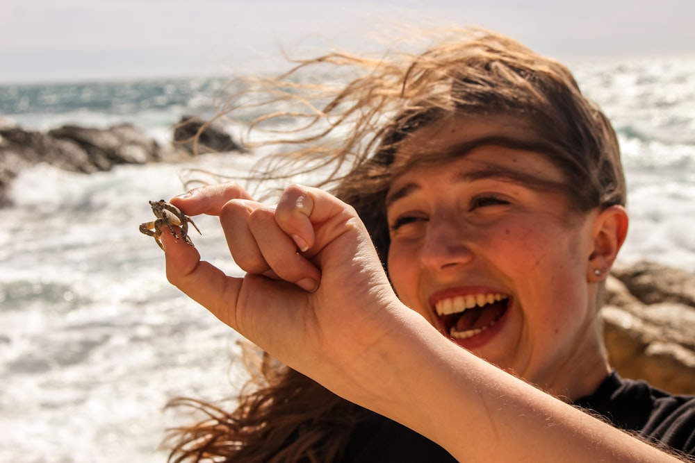 woman in black shirt holding brown dried leaf