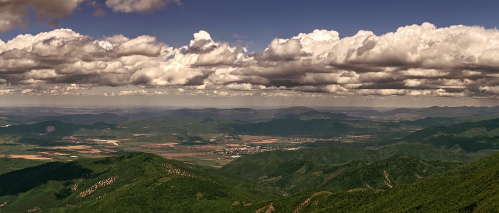 green mountains under white clouds and blue sky during daytime