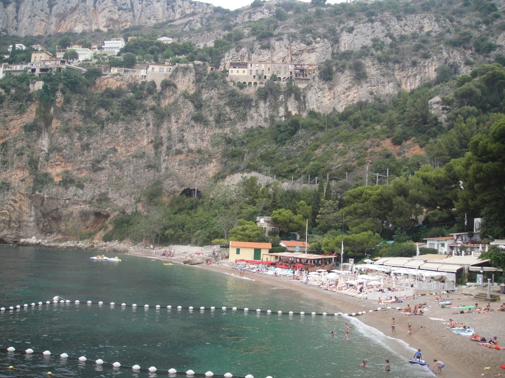 people on beach near mountain during daytime