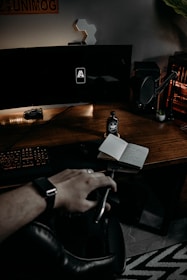 person holding black pen and white paper on brown wooden desk