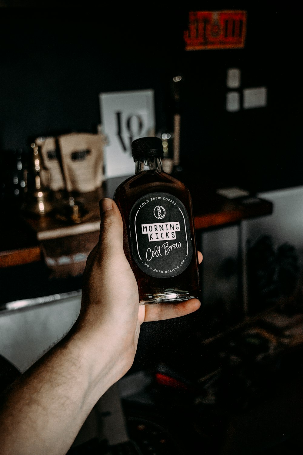 person holding black and brown bottle