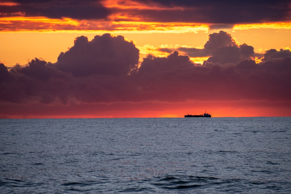 silhouette of boat on sea during sunset