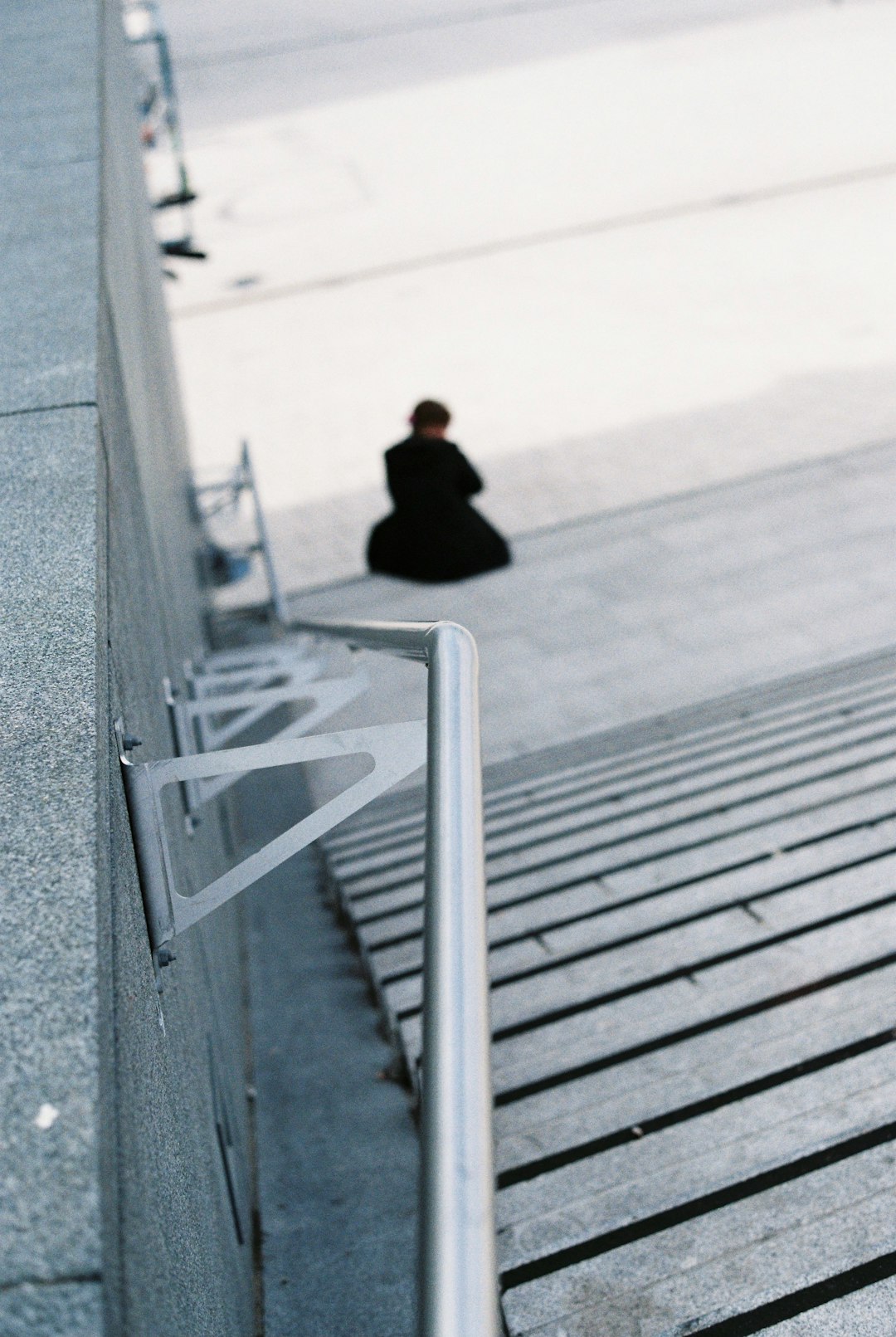 person in black jacket sitting on wooden stairs