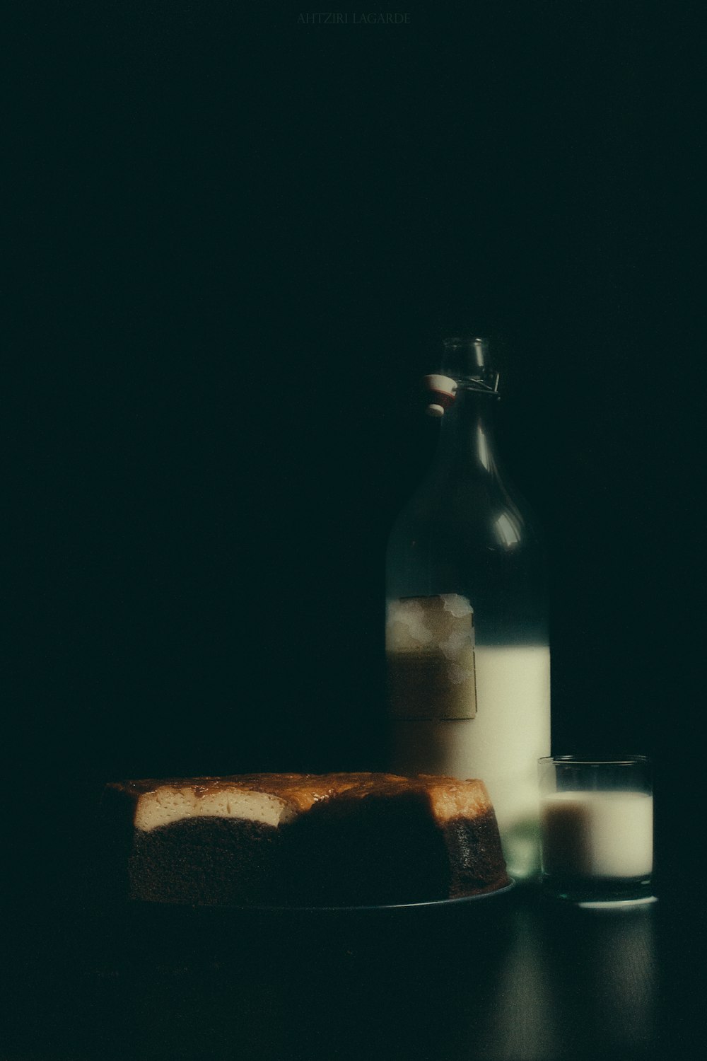 white pillar candle beside brown glass bottle