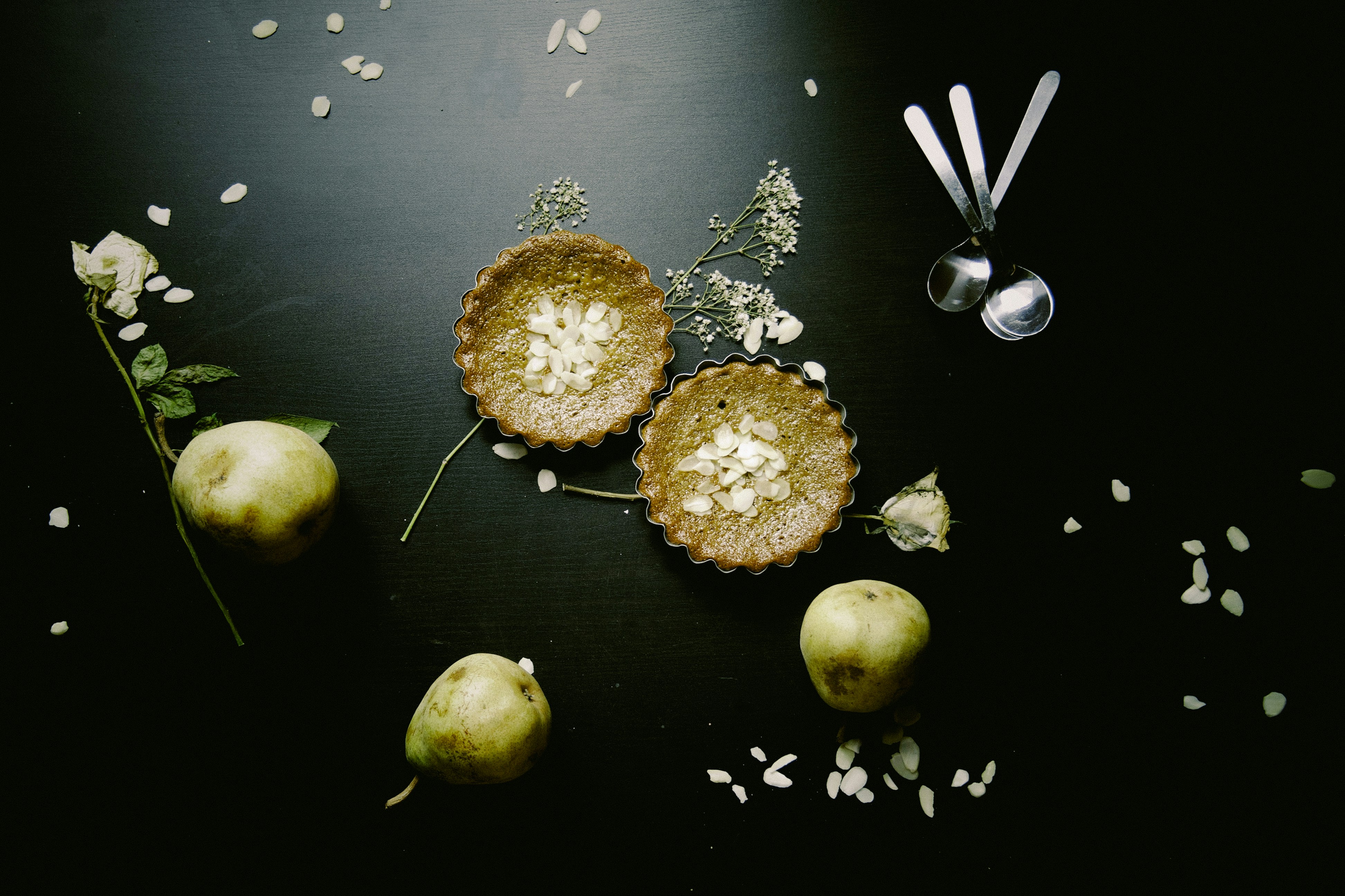 four green round fruits on black surface
