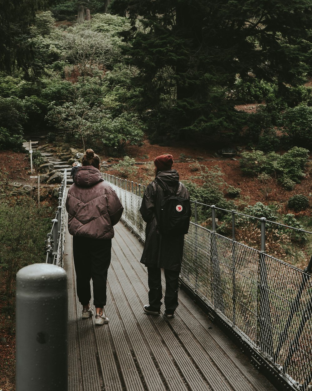 uomo e donna che camminano sul ponte durante il giorno