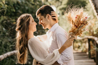 man in white dress shirt holding brown flower bouquet