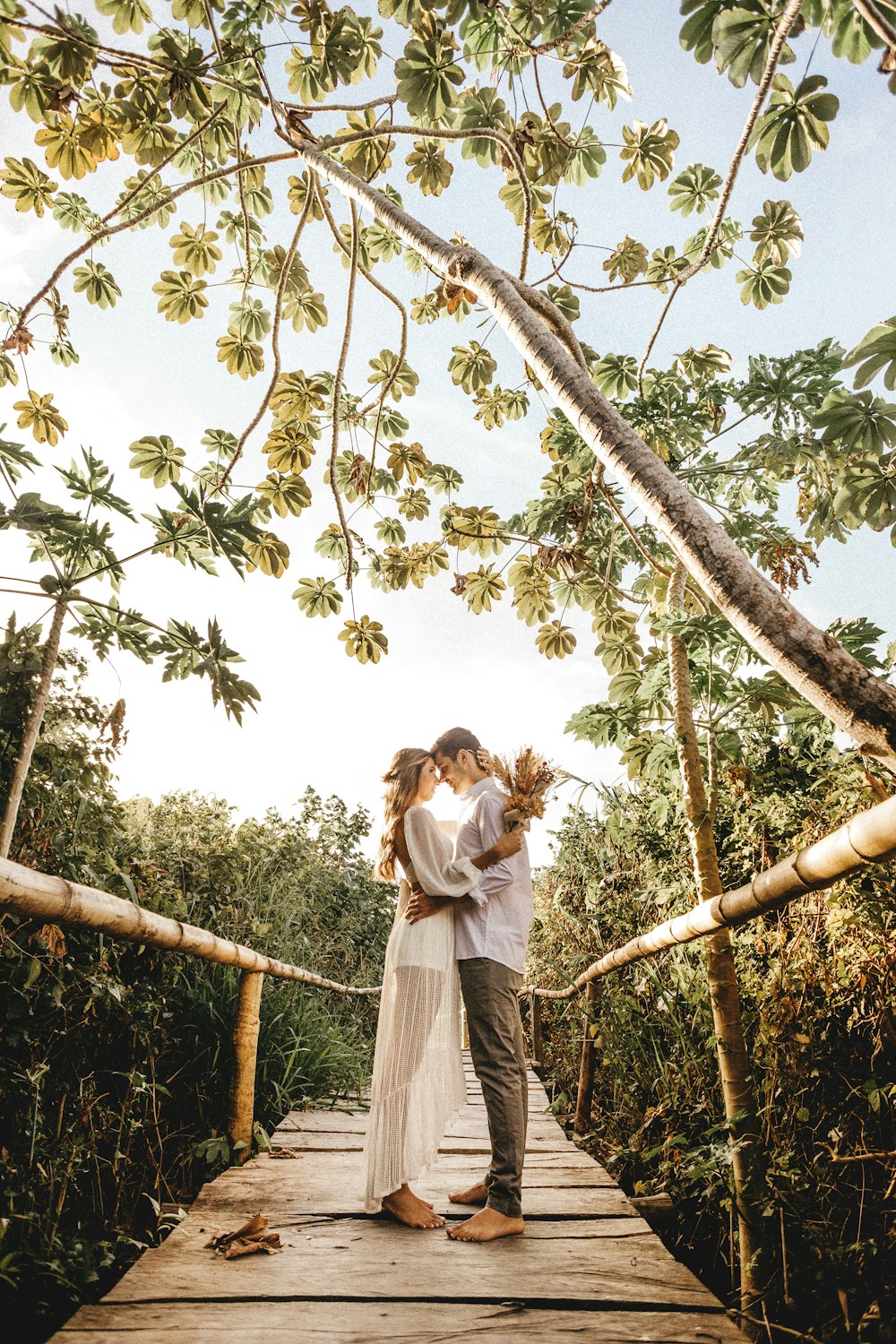 woman in white dress standing on tree branch during daytime