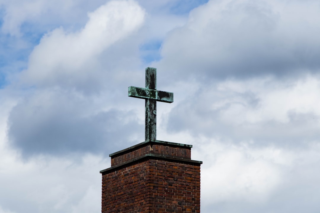 brown brick tower under white clouds during daytime