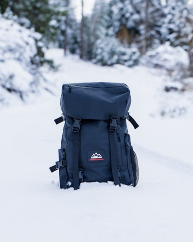 black backpack on snow covered ground