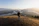 Veteran smiling with a backpack at a scenic mountain overlook during sunset
