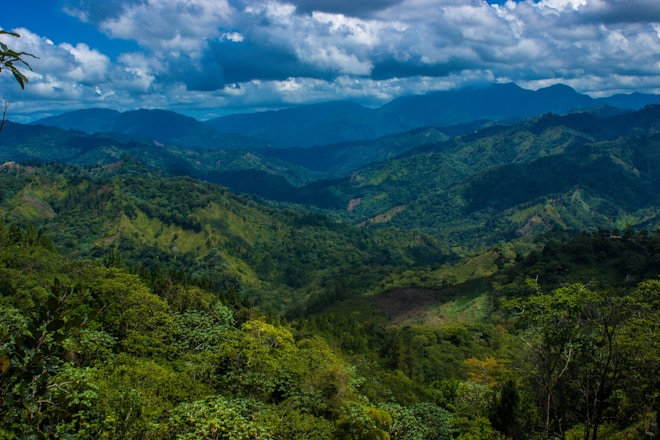 green mountains under blue sky and white clouds during daytime