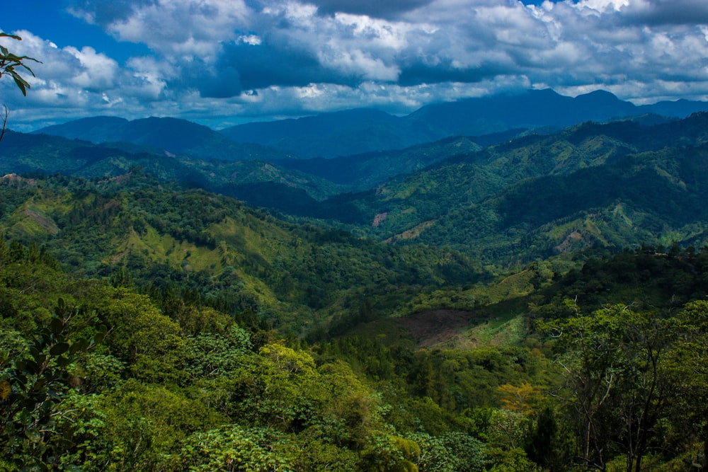 green mountains under blue sky and white clouds during daytime