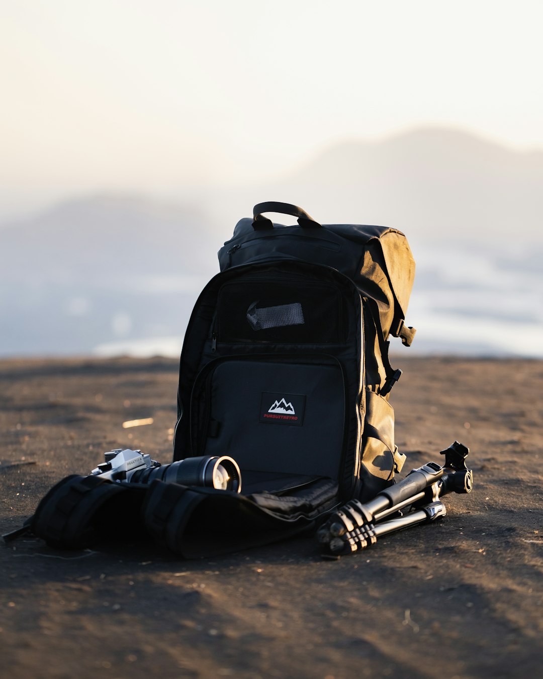 black and orange backpack on brown sand during daytime