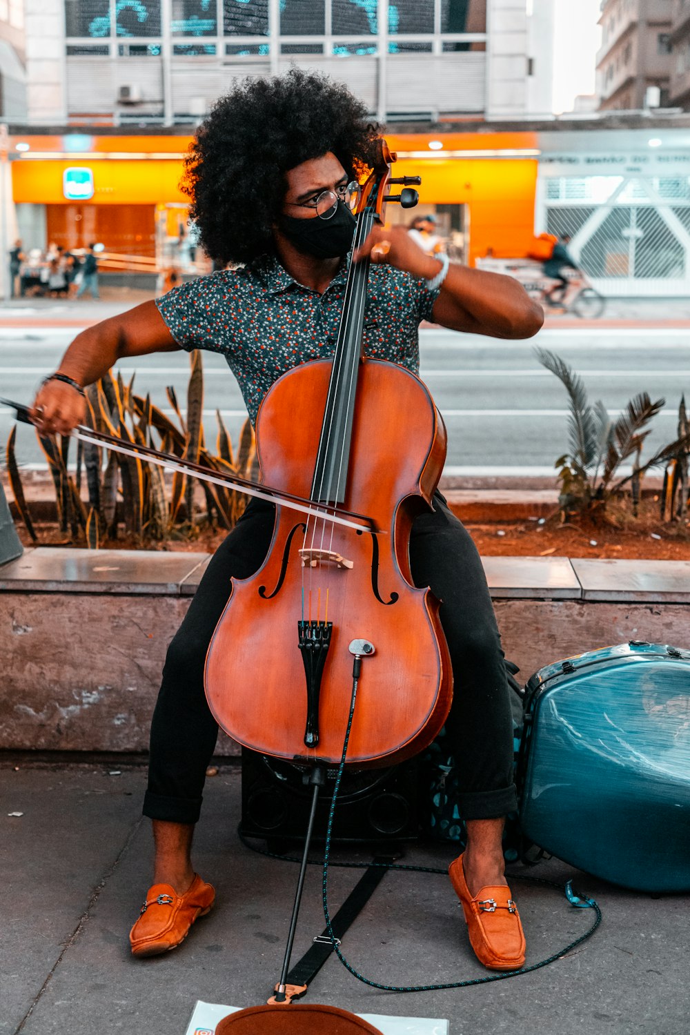 Frau im schwarz-weißen Kleid spielt braunes Cello