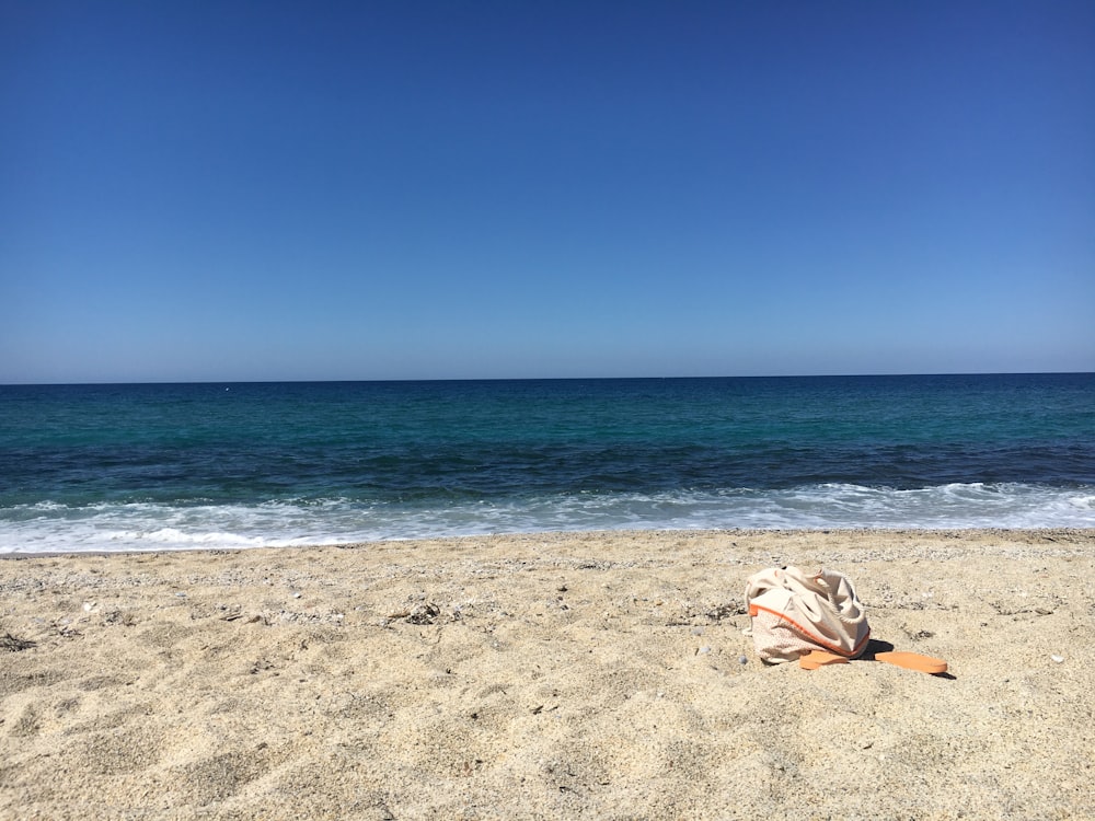 têxtil branco e marrom na praia durante o dia