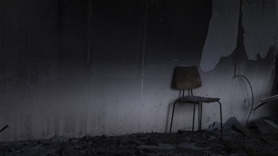 An abandoned chair in a corner of a deserted space.