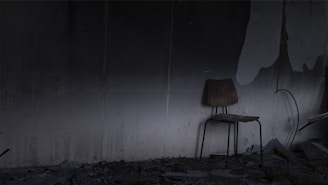 An abandoned chair in a corner of a deserted space.