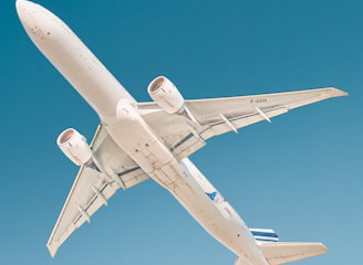 white airplane under blue sky during daytime