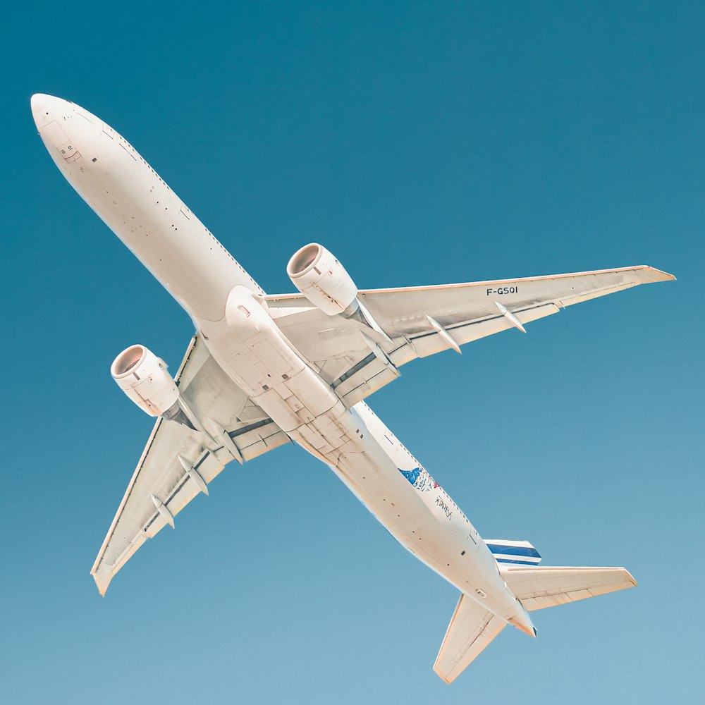 avion blanc sous le ciel bleu pendant la journée