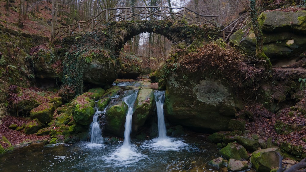 waterfalls under bridge during daytime