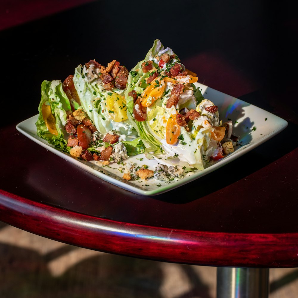 Plato cuadrado de cerámica blanca con ensalada de verduras