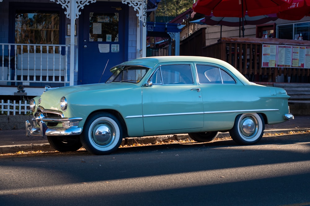 blue classic car parked on side of the road during daytime