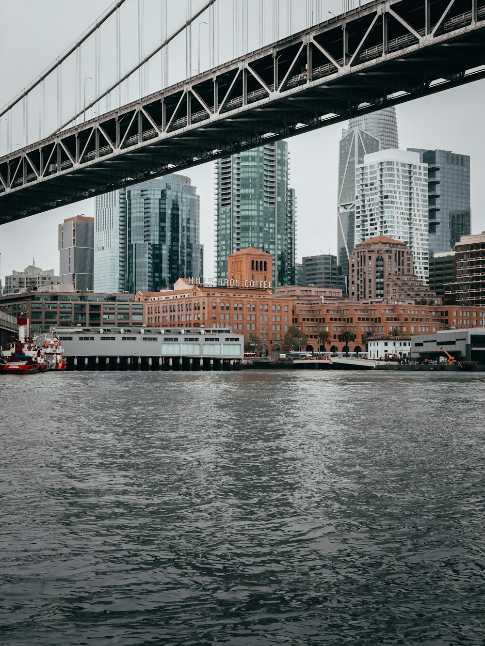 Bateau blanc et rouge sur l’eau près du pont pendant la journée