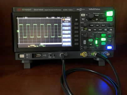 Close-up of a digital oscilloscope displaying waveforms in a modern lab setting.